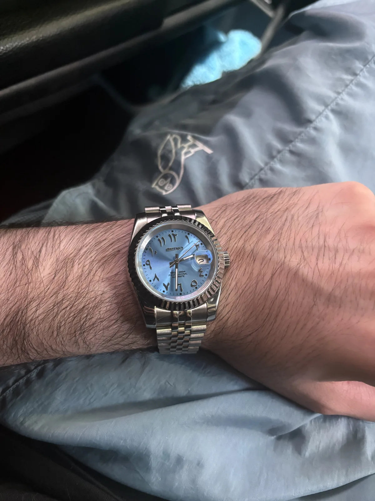 Blue dial watch worn on the wrist